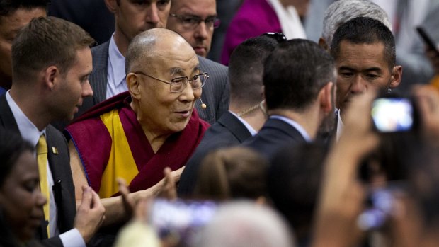 The Dalai Lama greets the crowd as he leaves after delivering his speech - A Peaceful Mind in a Modern World - at American University's Bender Arena in Washington.