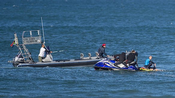 Mick Fanning looks on from the safety of a jet-ski as the water safety team continues to look for the shark that attacked him during the final of the JBay Open.