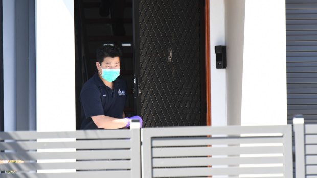 A NSW Police forensic officer at the house that police raided in Merrylands on Thursday. 