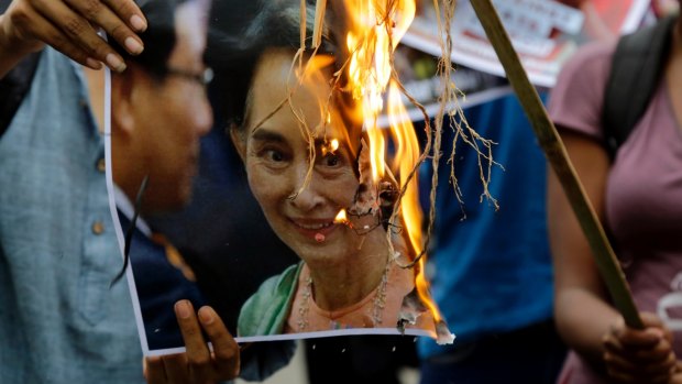 Reputation going up in flames: activists burn a poster of Aung San Suu Kyi.