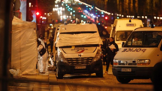 Forensic experts and police officers examine evidence from a police van on the Champs Elysees in Paris, France.
