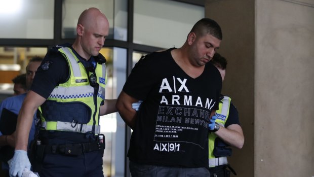 A man is taken away after a suspected brawl at Melbourne Magistrates Court. 