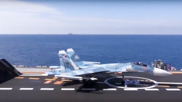 A Russian Su-33 fighter jet stands ready to take off the flight deck of the Admiral Kuznetsov aircraft carrier in the eastern Mediterranean Sea.
