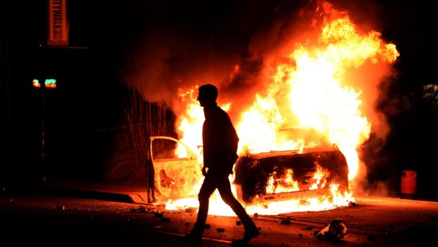 A burning police vehicle during clashes in Ferguson.