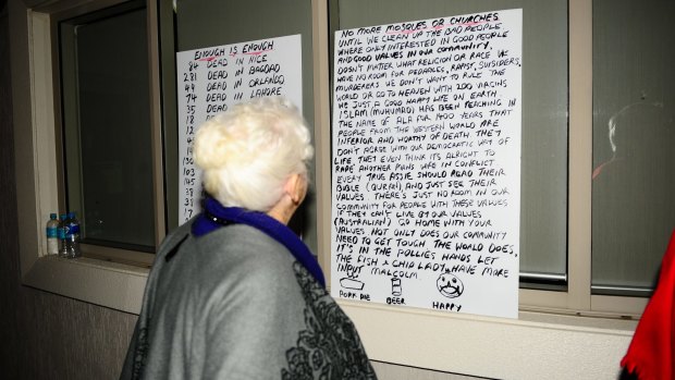 Cessnock Councillor Catherine Parsons looks at two protest placards left outside the council meeting.