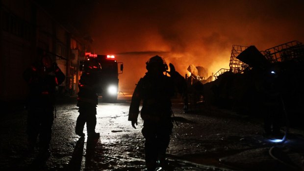 Israeli firefighters extinguish a burning factory hit by a rocket fired from the Gaza Strip on June 28, 2014 at an industrial zone in the southern city of Sderot. 