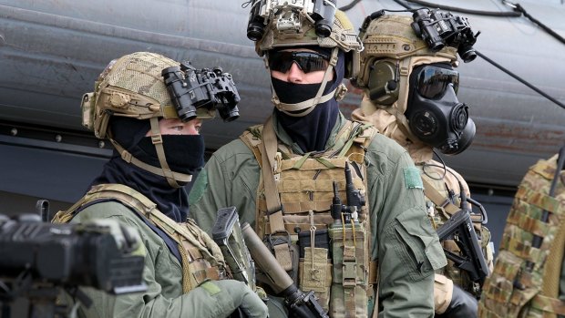 Armed and masked special forces troops at the announcement of the government's new policies on military involvement in terrorist incidents.