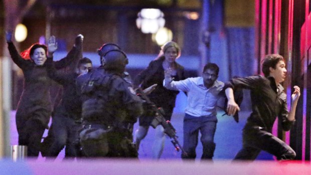 Hostages flee from the Lindt cafe in Martin Place during the early hours of December 16, 2014.