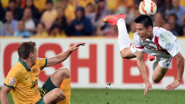 Australia's Alex Wilkinson clashes with China's Wu Lei.
