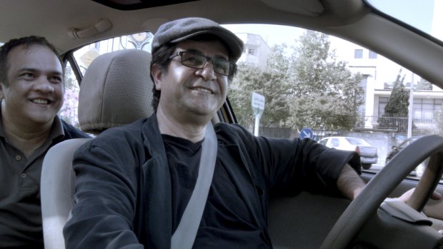 Jafar Panahi and a passenger in <i>Tehran Taxi</i>, a minimalist experiment where fiction and documentary mingle.