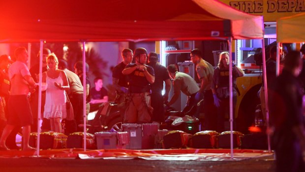 Medics treat the wounded as Las Vegas police respond to a shooting on the Las Vegas Strip on Sunday.