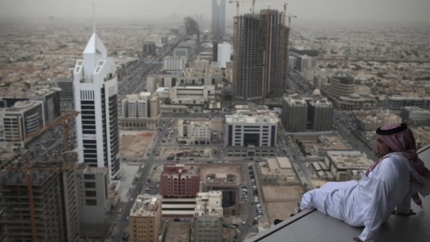 A man sits on a ledge high up on the Al Faisaliyah Centre tower in Riyadh, Saudi Arabia.