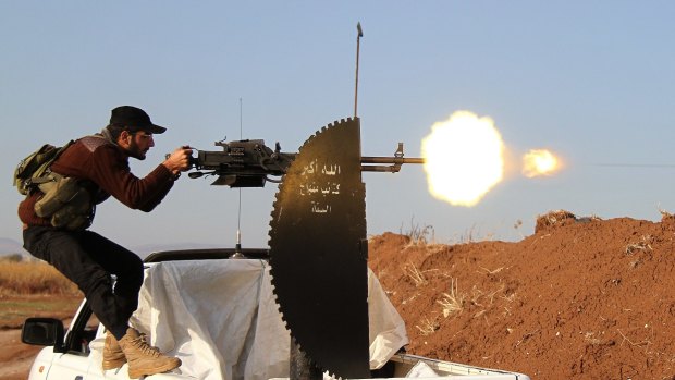 A Member of Syrian opposition group fires during clashes with IS militants in Aleppo, Syria.