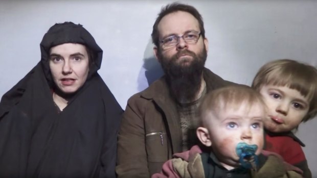 Caitlan Coleman talks in an undated Taliban video while her Canadian husband Joshua Boyle holds two of their children .