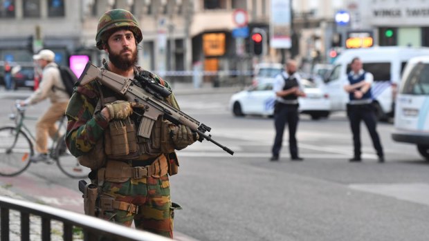 A Belgian Army soldier stands outside Brussels Central Station. While the risk of being caught in a terror attack remains low, the perception of the public - and tourists - is another matter.