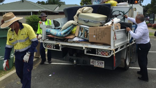 Gold Coast Mayor Tom Tate helps workers collect illegally dumped kerbside rubbish. 