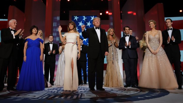 President Donald Trump acknowledges the crowd with First Lady Melania Trump, Vice-President Mike Pence and his wife Karen, left, and their families at the Freedom Ball.