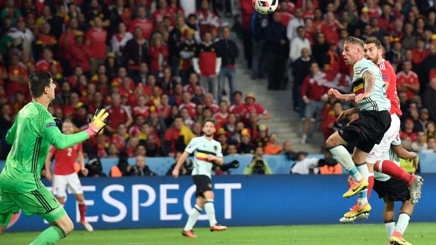 Sam Vokes, in red, scores Wales' third goal past Belgium goalkeeper Thibaut Courtois.