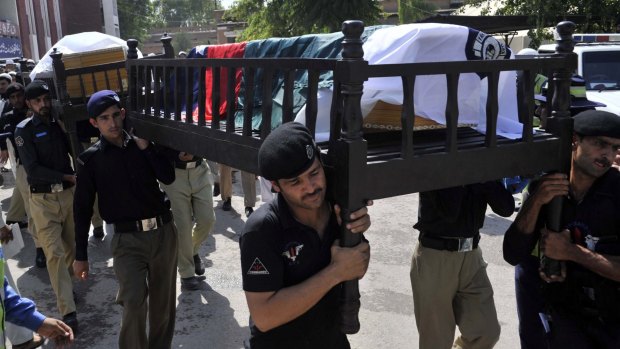 Pakistani policemen carry the coffins of their colleagues, killed in a Taliban suicide bomb attack last week.
