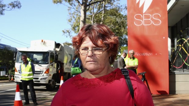 Mt Druitt resident and Struggle Street subject Peta Kennedy stands outside SBS as rubbish trucks blockade the broadcaster in protest.