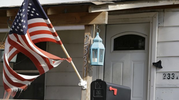 A tattered flag flies in front of a home where Julian Hernandez lived with his father, Bobby Hernandez in Cleveland. 