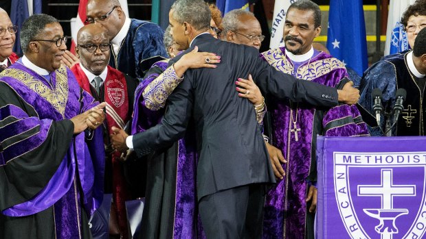 President Barack Obama is embraced by clergy members after delivering the eulogy at the funeral service for Clementa Pinckney.