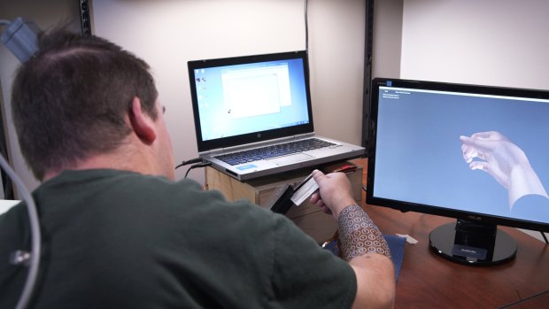 Ian Burkhart, who is paralysed from the neck down, controls the muscles of his right hand using a computer chip implanted in his brain. 