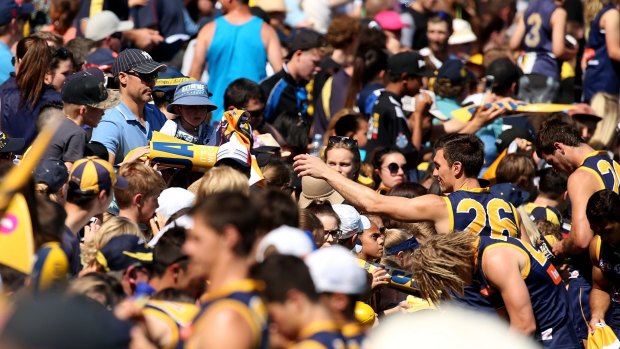 Sam Butler signs autographs during a West Coast training session at Domain Stadium on Monday.