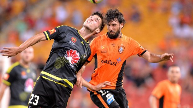 Head-to-head: Thomas Broich of the Roar and Matthew Ridenton of the Phoenix challenge for the ball.