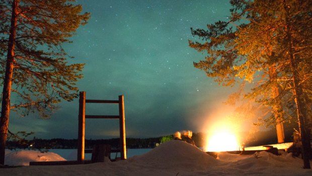 Bonfire under the Northern Lights in Oulanka National Park.