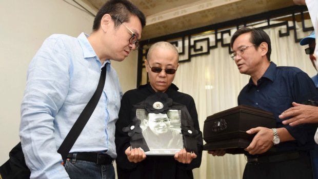 Liu Xia, centre, holds a portrait of her husband Liu Xiaobo during his funeral in Shenyang, north-eastern China, on Saturday.