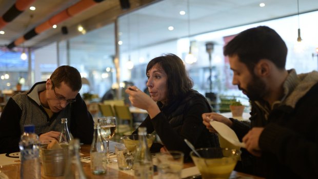 Time out: Simona Levi, 48, from Italy, centre, Sergio Salgado, 35, left, and Alfa Sanchez, eat in a restaurant during from a session working with Xnet in Barcelona.
