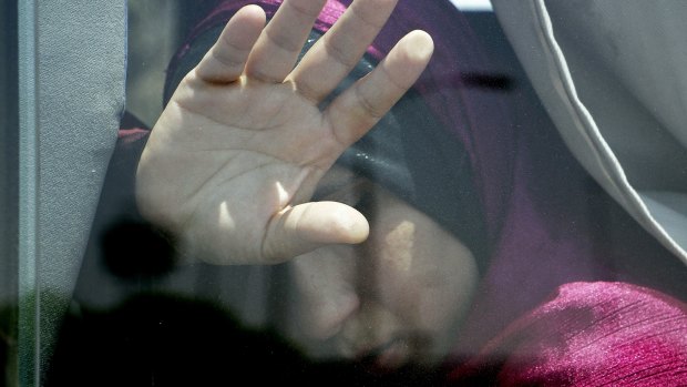 A relative of a passenger on the EgyptAir flight puts her hand on the window from inside a bus at Cairo airport.