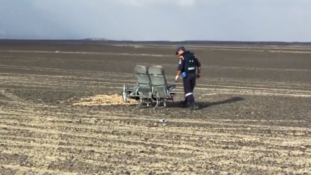 A Russian Emergency Situations Ministry employee examines damaged seats from the plane that crashed in Egypt.