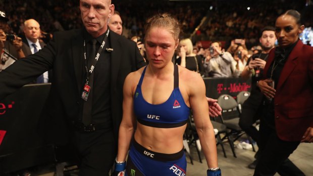 Bloodied and beaten: Ronda Rousey leaves the Octagon after her loss in December.