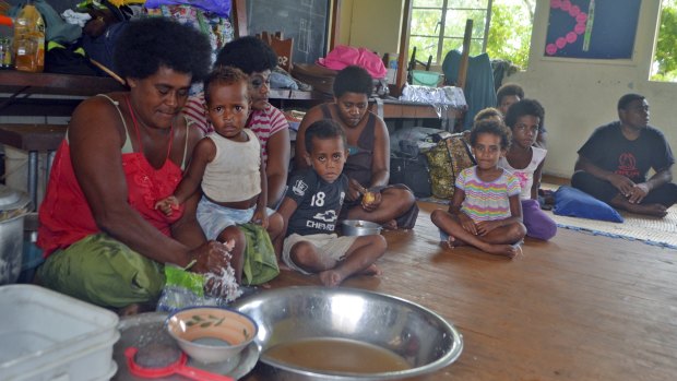 Families from the Wainiveidilo settlement prepare a meal at a school used as an evacuation centre in Navua, Fiji.