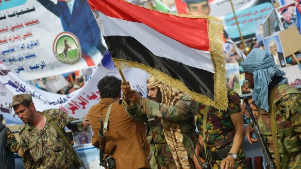 A soldier waves Yemen's national flag as he attends a ceremony to celebrate the 35th anniversary of the founding of the Popular Conference Party, in Sanaa, Yemen on Thursday.