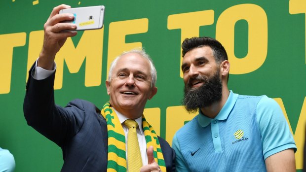 Prime Minister Malcolm Turnbull takes a selfie with Socceroos captain Mile Jedinak.