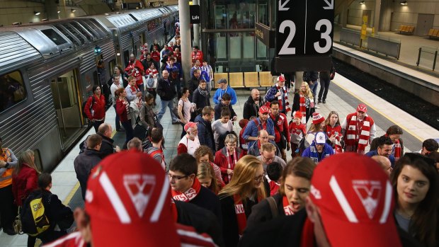 Sydney Swans fans arrive at Olympic Park station for Friday's preliminary final. The scramble to make it to the Melbourne grand final is on.