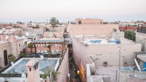 Pink-hued buildings stand among narrow alleyways in Marrakech.