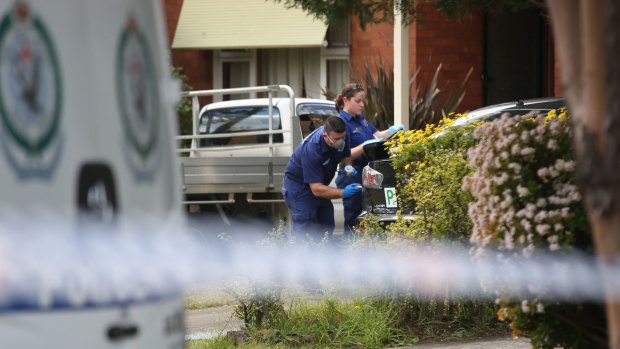 Police and forensic investigators survey the scene following the death in Panania.