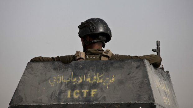 A soldier from Iraq's elite counterterrorism forces looks out from the gun turret of a Humvee as troops gather on the edge of the Shuhada neighbourhood in Islamic State-held Fallujah on Wednesday. 