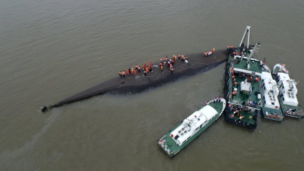 An aerial view shows rescue workers searching on the sunken ship.
