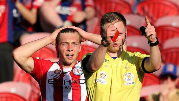 Referee Adam Fielding issues a red card to Jacob Melling of Melbourne City.