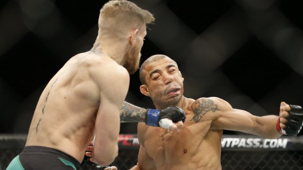 New champ: Conor McGregor sends Jose Aldo to the floor with a perfectly timed punch in the UFC championship bout. 