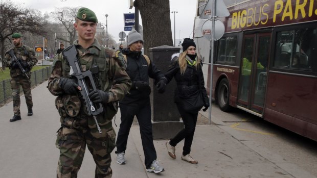 Paris on high alert: French soldiers patrol next to the Eiffel Tower after a shooting at a French satirical magazine, in Paris.