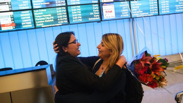 Sahar Muranovic, left, embraces her sister Sara Yarjani, an Iranian student who was detained for 23 hours and deported, as they are reunited at Los Angeles International Airport.