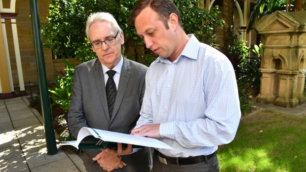 Michael Forde (left) and Steven Miles with the independent report into the Queensland towing industry.