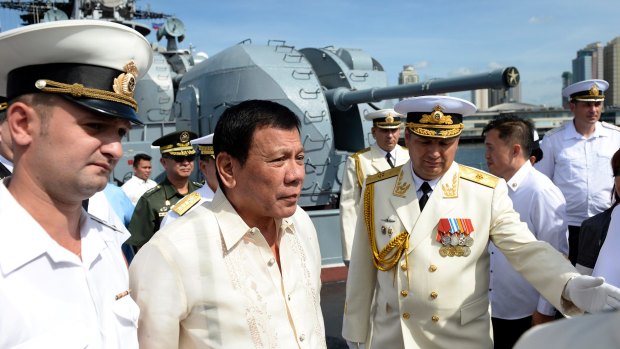 Russia's Rear Admiral Eduard Mikhailov, front right, leads the way as he guides Philippine President Rodrigo Duterte at the anti-submarine navy ship docked in Manila, Philippines.