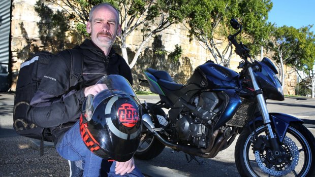 Chris Goodwin with his motorcycle which he uses to deliver Uber Eats around Sydney. 